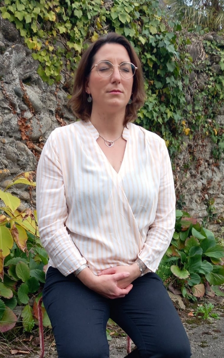 Femme assise dans un jardin luxuriant.
